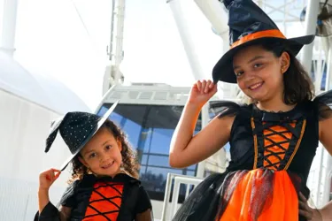 2 girls dressed up in witches costumes celebrating the opening of the Orlando Eye at ICON Park in Orlando Florida